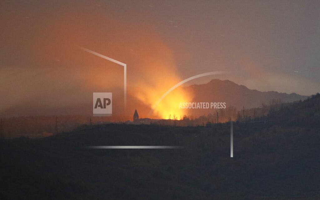 Uncredited FILE - in this Saturday, Nov. 7, 2020 file photo, bursts of explosions, smoke and flame are seen during fighting between Armenian and Azerbaijan's forces near the Holy Savior Cathedral in Shushi, outside Stepanakert, the separatist region of Nagorno-Karabakh. Armenia is taking its decades long territorial dispute with Azerbaijan — that erupted into armed conflict again last year — to the United Nations’ highest court. Armenia filed a case at the International Court of Justice alleging breaches by Azerbaijan of an international convention that aims to eliminate racial discrimination, the court announced late Thursday Sept. 17, 2021. (AP Photo/File)