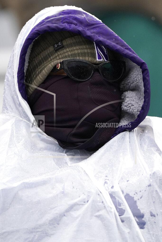 Nam Y. Huh A Northwestern fan covers up for the rain as he watches an NCAA college football game between Illinois and Northwestern during the second half in Evanston, Ill., Saturday, Dec. 12, 2020. Northwestern won 28-10. (AP Photo/Nam Y. Huh)