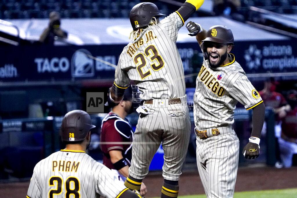 Rick Scuteri San Diego Padres' Eric Hosmer celebrates with Fernando Tatis Jr. (23) and Tommy Pham (28) after hitting a two-run home run against the Arizona Diamondbacks in the sixth inning during a baseball game, Sunday, Aug 16, 2020, in Phoenix. (AP Photo/Rick Scuteri)
