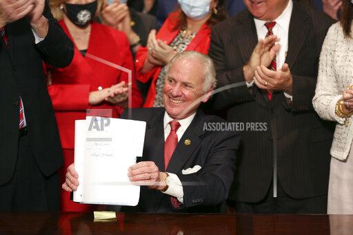 FILE - South Carolina Gov. Henry McMaster holds up a bill banning almost all abortions in the state after he signed it into law on Thursday, Feb. 18, 2021, in Columbia, S.C. Appellate arguments over a lawsuit challenging South Carolina’s abortion law have been pushed into the new year. Oral arguments in the case had originally been planned for next month, but the 4th U.S. Circuit Court of Appeals has rescheduled them for the last week in January 2022, according to an order from the court. (AP Photo/Jeffrey Collins, File)