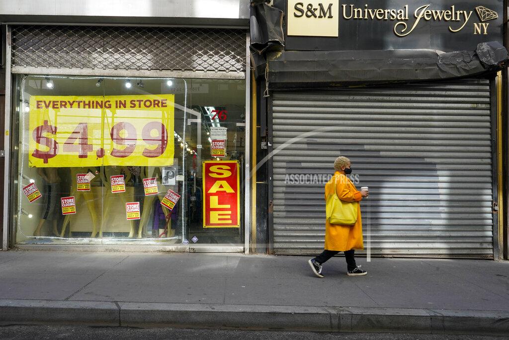 A pedestrian walks past a shuttered store and one that is having a store closing sale in New York's Financial District, Tuesday, March 23, 2021. The U.S. economy grew at an annual rate of 4.3% in the final three months of 2020, slightly faster than previously estimated, as recovery expectations for 2021 rise along with vaccinations as the U.S. unleashes nearly $2 trillion in government support. (AP Photo/Mary Altaffer)