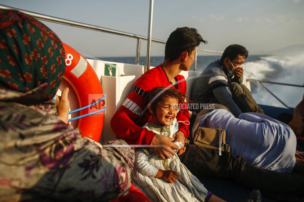 Emrah Gurel Migrants sit on a Turkish coast guard vessel after they were pulled off life rafts, during a rescue operation in the Aegean Sea, between Turkey and Greece, Saturday, Sept. 12, 2020. Turkey is accusing Greece of large-scale pushbacks at sea — summary deportations without access to asylum procedures, in violation of international law. The Turkish coast guard says it rescued over 300 migrants "pushed back by Greek elements to Turkish waters" this month alone. Greece denies the allegations and accuses Ankara of weaponizing migrants. (AP Photo/Emrah Gurel)