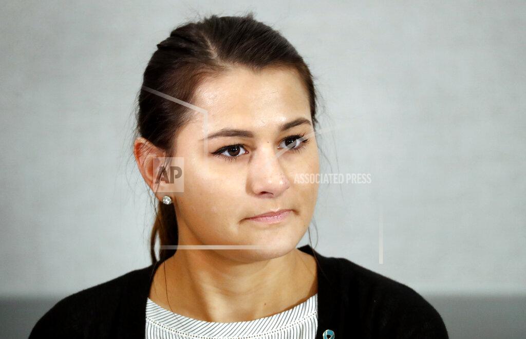 Paul Sancya Bailey Kowalski listens to a question during a news conference in East Lansing, Mich., Thursday, April 11, 2019. The 22-year-old Michigan State University student is speaking publicly a year after suing the school, alleging that three former men's basketball players raped her in 2015 and that she was discouraged by counseling center staff from reporting what happened. (AP Photo/Paul Sancya)