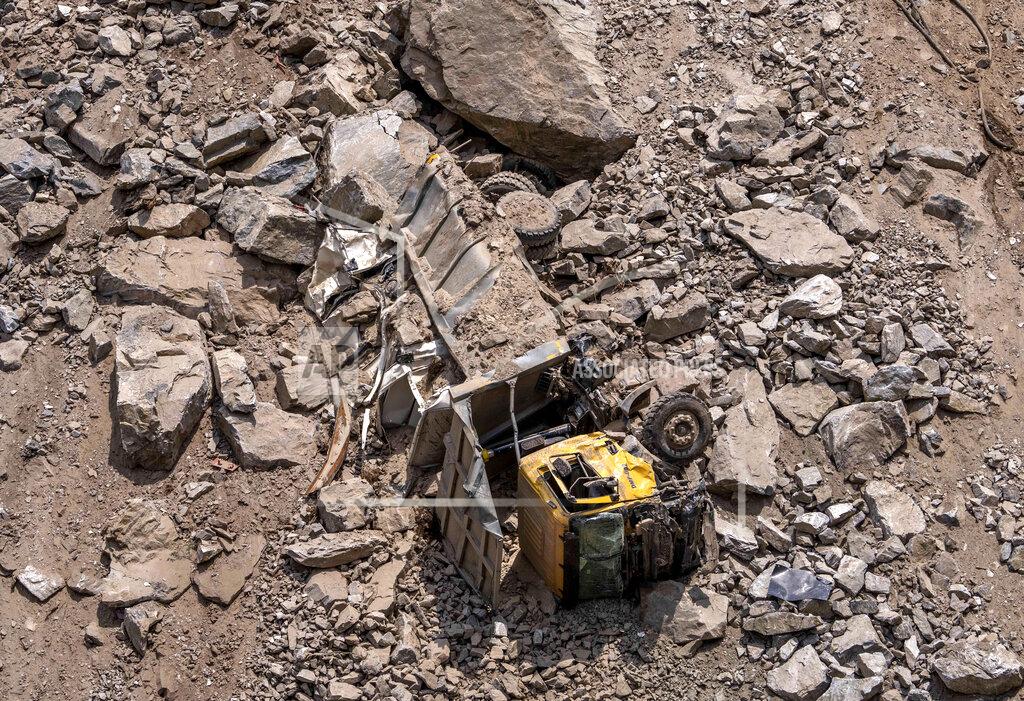Dar Yasin A damaged truck is buried under rocks and stones from the rubble of a collapsed tunnel in Ramban district, south of Srinagar, Indian controlled Kashmir, Friday, May 20, 2022. An official in Indian-controlled Kashmir said Friday that 10 workers were trapped after part of a road tunnel collapsed in the Himalayan region. (AP Photo/Dar Yasin)