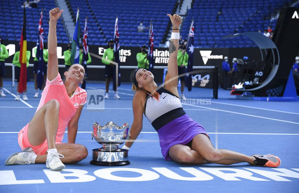 Andy Brownbill Belgium's Elise Mertens, left, and Aryna Sabalenka of Belarus gesture as they pose with their trophy after defeating Barbora Krejcikova and Katerina Siniakova of the Czech Republic in the women's doubles final at the Australian Open tennis championship in Melbourne, Australia, Friday, Feb. 19, 2021.(AP Photo/Andy Brownbill)
