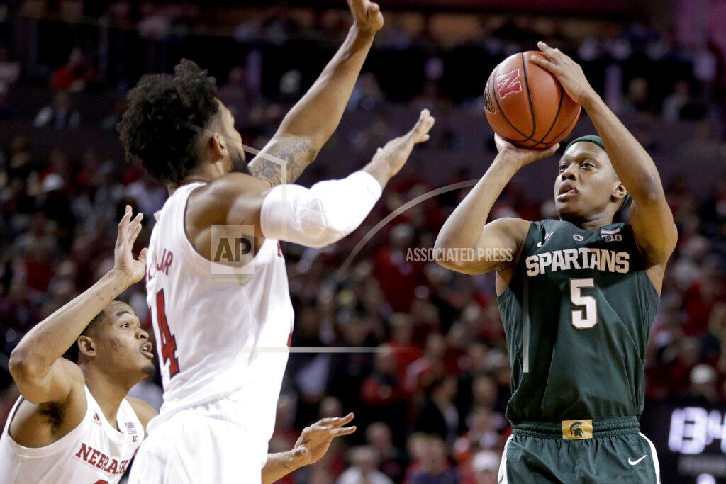 FILE - In this Jan. 17, 2019, file photo, Michigan State's Cassius Winston (5) shoots against Nebraska's James Palmer Jr. and Isaac Copeland Jr. (14) during the second half of an NCAA college basketball game in Lincoln, Neb. Winston has developed into a player of the year candidate, leading No. 6 Michigan State as it contends for a Big Ten title and perhaps top seeding in the NCAA tournament while two of its top players are injured. (AP Photo/Nati Harnik, File)