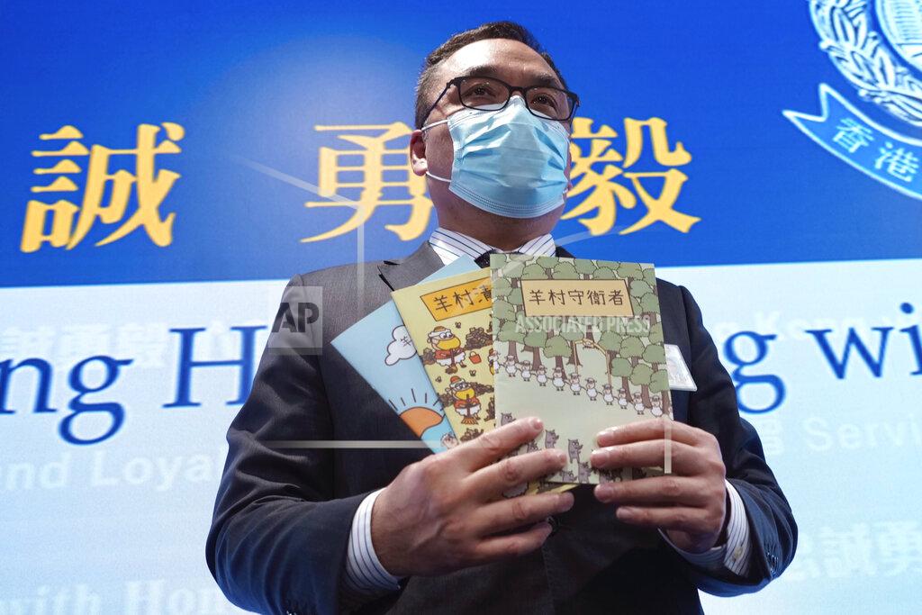 Vincent Yu Li Kwai-wah, senior superintendent of Police National Security Department, poses with evidence including three children's books on stories that revolve around a village of sheep which has to deal with wolves from a different village, before a press conference in Hong Kong Thursday, July 22, 2021. Hong Kong's national security police on Thursday arrested five people from a trade union of the General Association of Hong Kong Speech Therapists on suspicion of conspiring to publish and distribute seditious material, in the latest arrests made amid a crackdown on dissent in the city.(AP Photo/Vincent Yu)