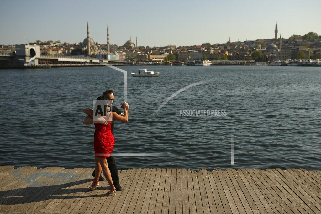 Emrah Gurel A couple dance by the Golden Horn leading to the Bosphorus Strait separating Europe and Asia, in Istanbul, Friday, May 14, 2021. Turkey is in the final days of a full coronavirus lockdown and the government has ordered people to stay home and businesses to close amid a huge surge in new daily infections. But millions of workers are exempt and so are foreign tourists. Turkey is courting international tourists during an economic downturn and needs the foreign currencies that tourism brings to help the economy as the Turkish lira continues to sink. (AP Photo/Emrah Gurel)