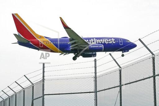 A Southwest Airlines flight lands at General Mitchell International Airport, Wednesday, Oct. 13, 2021, in Milwaukee. Southwest will let unvaccinated employees keep working past early December instead of putting them on unpaid leave if they apply for an exemption on medical or religious grounds. (AP Photo/Morry Gash)