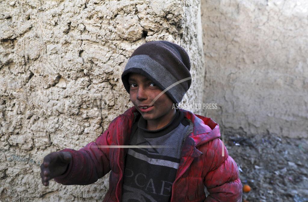 Rahmat Gul An internally displaced boy poses for a photograph outside his temporary home in the city of Kabul, Afghanistan, Wednesday, Dec. 30, 2020. Save the Children has warned that more than 300,000 Afghan children face freezing winter conditions that could lead to illness, in the worst cases death, without proper winter clothing and heating. (AP Photo/Rahmat Gul)