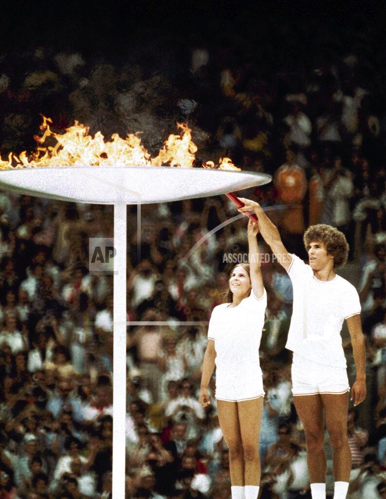 Uncredited Gymnastics athlete Sandra Henderson, left, and track and field athlete Stéphane Préfontaine Lighting of the Olympic Flame during the 1976 Montreal Olympics, July 17, 1976. (AP Photo)