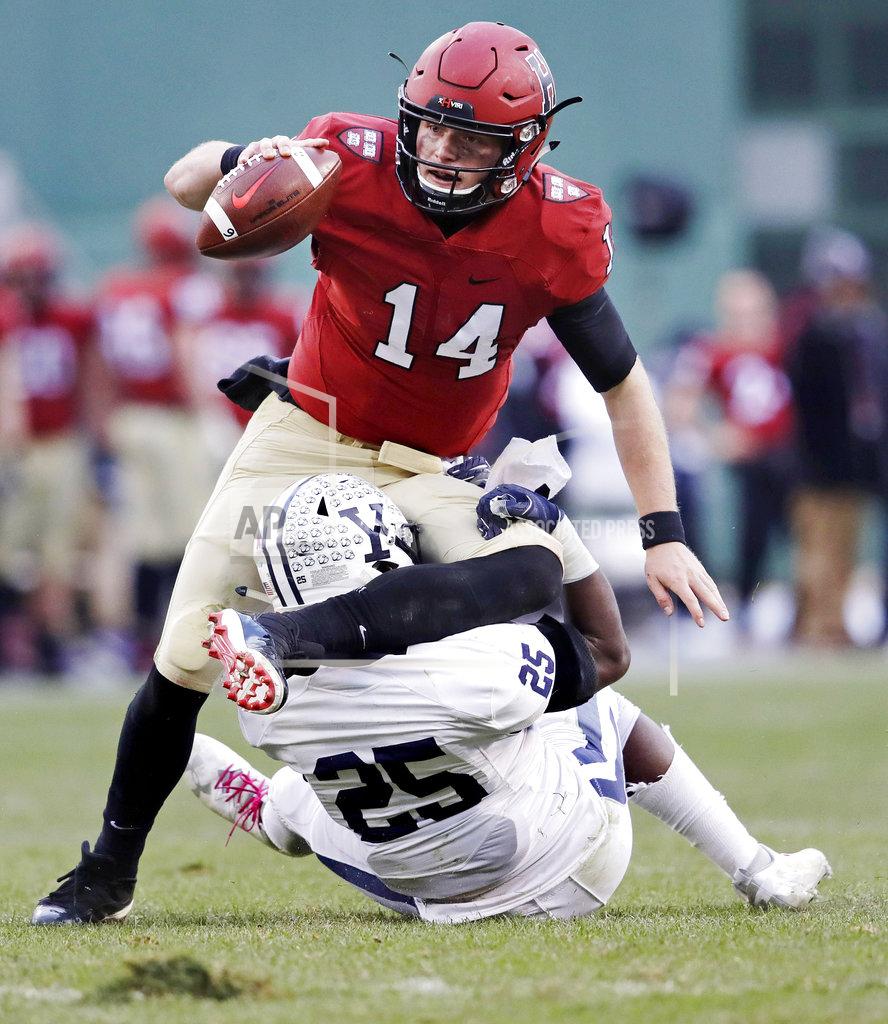 Charles Krupa Harvard quarterback Tom Stewart (14) is sacked by Yale linebacker Micah Awodiran (25) during the second half of an NCAA college football game at Fenway Park in Boston, Saturday, Nov. 17, 2018. (AP Photo/Charles Krupa)
