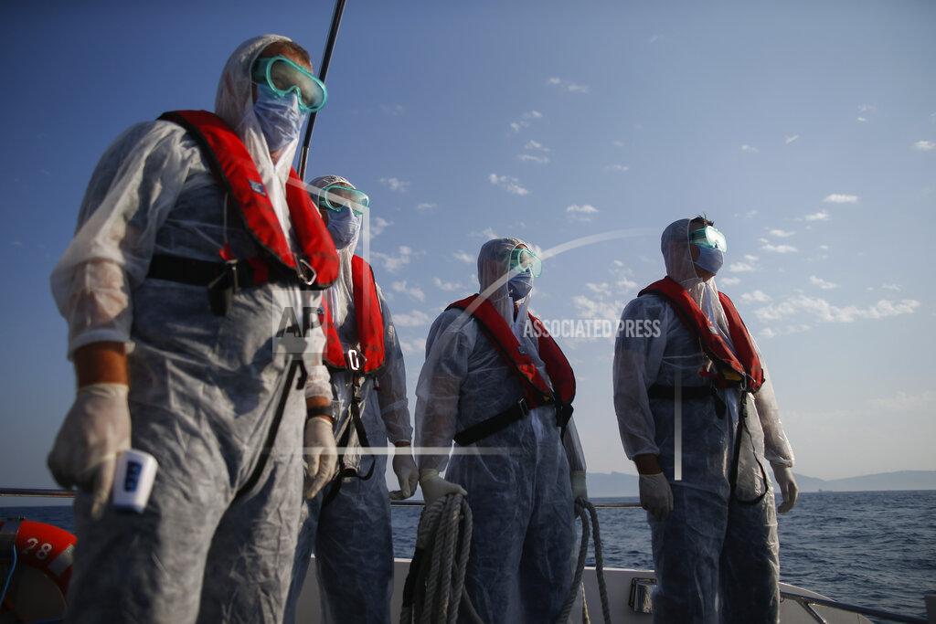 Emrah Gurel Turkish coast guard officers, wearing protective gear to help prevent the spread of the coronavirus, approach a life raft with migrants during a rescue operation in the Aegean Sea, between Turkey and Greece, Saturday, Sept. 12, 2020. Turkey is accusing Greece of large-scale pushbacks at sea — summary deportations without access to asylum procedures, in violation of international law. The Turkish coast guard says it rescued over 300 migrants "pushed back by Greek elements to Turkish waters" this month alone. Greece denies the allegations and accuses Ankara of weaponizing migrants. (AP Photo/Emrah Gurel)