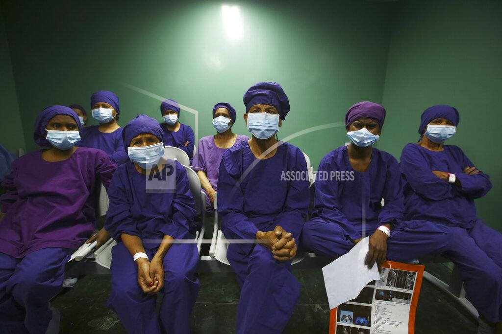 Niranjan Shrestha Nepalese patients wait to receive anesthesia before eye surgery at the Tilganga Eye Center in Kathmandu, Nepal, Friday, March 26, 2021. Nepal’s “God of Sight” eye doctor renowned for his innovative and inexpensive cataract surgery for the poor is taking his work beyond the Himalayan mountains to other parts of the world so there is no more unnecessary blindness in the world. Dr. Sanduk Ruit, who has won many awards for his work and performed some 130,000 cataract surgery in the past three decades, is aiming to expand his work beyond the borders of his home country and the region to go globally. (AP Photo/Niranjan Shrestha)