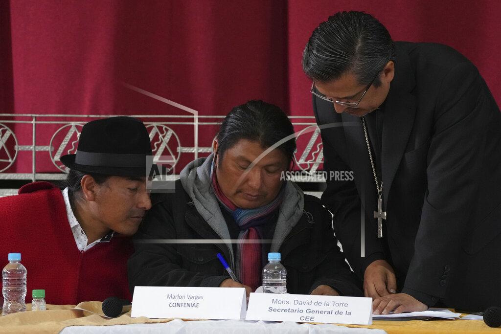Dolores Ochoa Indigenous leaders, Leonidas Iza, left, and Marlon Vargas, center, revise an agreement document with Monsignor David de la Torre during a dialogue session with the government, with Catholic Church representatives as mediador, at the Episcopal Conference headquarters in Quito, Ecuador, Thursday, June 30, 2022. The two groups are discussing solutions that could lead to the end of a strike over gas prices that has paralyzed parts of the country for two weeks. (AP Photo/Dolores Ochoa)