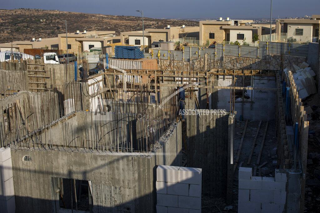 Ariel Schalit Palestinians built new houses in the West Bank Jewish settlement of Bruchin near the Palestinian town of Nablus, Monday, Oct. 25, 2021. Israel is expected to move forward with thousands of new homes for Jewish settlers in the West Bank this week, a settlement watchdog group said Sunday. (AP Photo/Ariel Schalit)