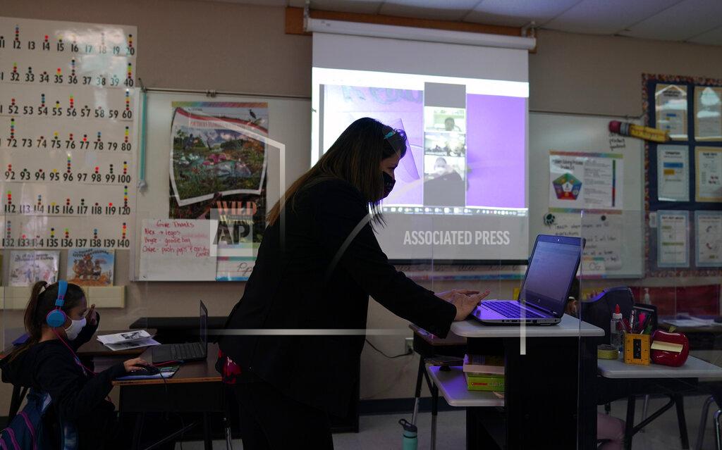 Eric Gay Wylona Rogers teaches students attending a class in-person as well as students attending virtually at Driggers Elementary School, Monday, Feb. 8, 2021, in San Antonio. After seeing two academic years thrown off course by the pandemic, school leaders around the country are planning for the possibility of more distance learning next fall at the start of yet another school year. (AP Photo/Eric Gay)
