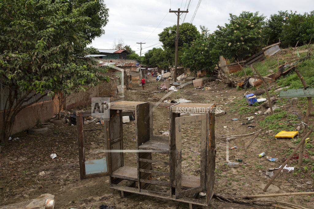 Moises Castillo A muddied wardrobe stands amid the rubble of homes destroyed by last year's hurricanes Eta and Iota in La Lima, on the outskirts of San Pedro Sula, Honduras, Monday, Jan. 11, 2021. The suburb of San Pedro Sula has seen small businesses begin to reopen, but in outlying neighborhoods, the streets are still full of debris, dead animals, snakes and burning mattresses. (AP Photo/Moises Castillo)