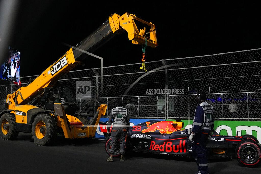Hassan Ammar Race marshals lift a car from Red Bull driver Max Verstappen of the Netherlands after he hit a wall during qualifying for the Saudi Arabian Grand Prix in Jiddah, Saturday, Dec. 4, 2021. (AP Photo/Hassan Ammar)