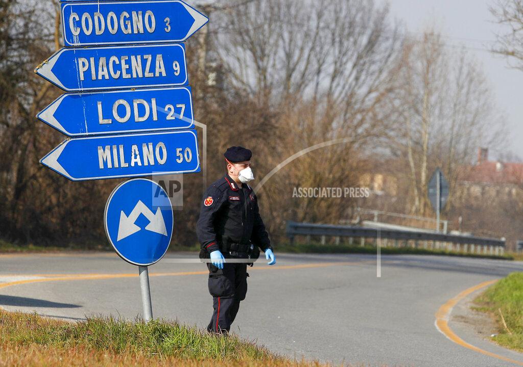 Antonio Calanni FILE - In thisMonday, Feb. 24, 2020 file photo, a Carabinieri (Italian paramilitary police) officer checks transit to or from the cordoned area in Codogno, some 50 kilometers South-East of Milan, Italy. Italy delivered the first shocking confirmation of locally transmitted coronavirus infections outside of Asia a year ago Sunday, with back-to-back revelations of cases more than 150 kilometers (nearly 100 miles) apart in the country's north. First, a 38-year-old man in Codogno, an industrial town in the Lombardy region, tested positive for COVID-19, sending panicked residents to pick up their children from school, stock up on provisions at grocery stores and search in vain for surgical masks at pharmacies. (AP Photo/Antonio Calanni, File)