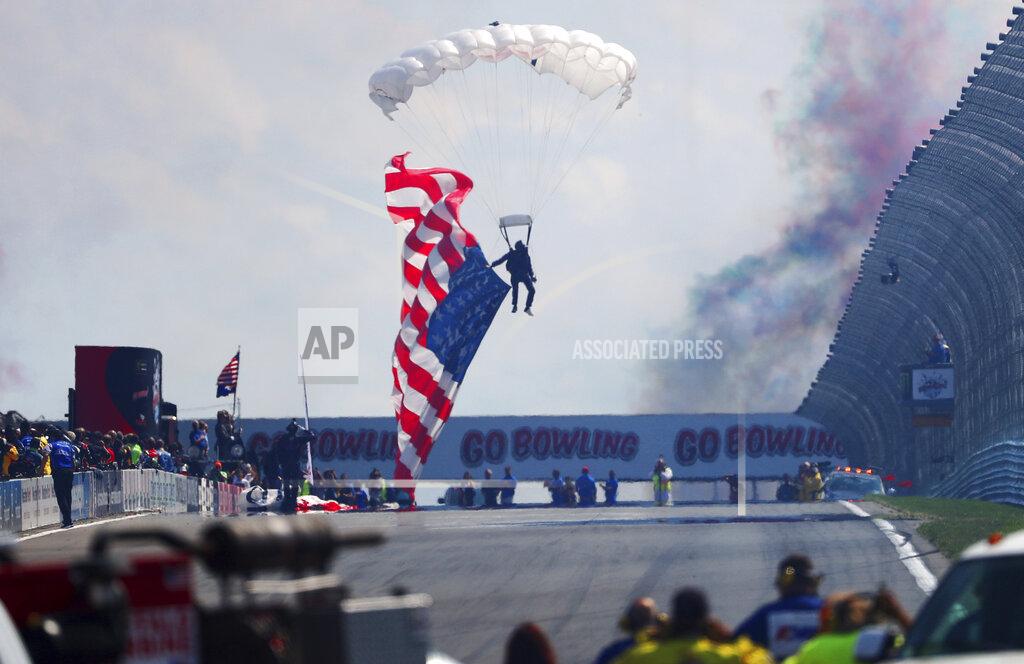 John Munson A parachute jumper lands with a large American flag before the start of a NASCAR Cup Series auto race at Watkins Glen International, Sunday, Aug. 4, 2019, in Watkins Glen, N.Y. (AP Photo/John Munson)