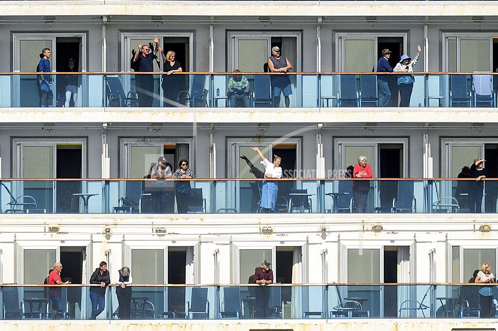 Noah Berger FILE - In this March 9, 2020, file photo, passengers aboard the Grand Princess celebrate as they arrive in Oakland, Calif. A year ago, the Grand Princess captured the world's attention when it became clear the coronavirus pandemic had arrived on the shore of California, making the virus real to millions in the United States. San Francisco reached the least-restrictive yellow tier for a brief period in October, the only urban area to do so, before an alarming surge in cases forced a retreat. Now, in early May 2021, California has the lowest case rate in the country. (AP Photo/Noah Berger, File)