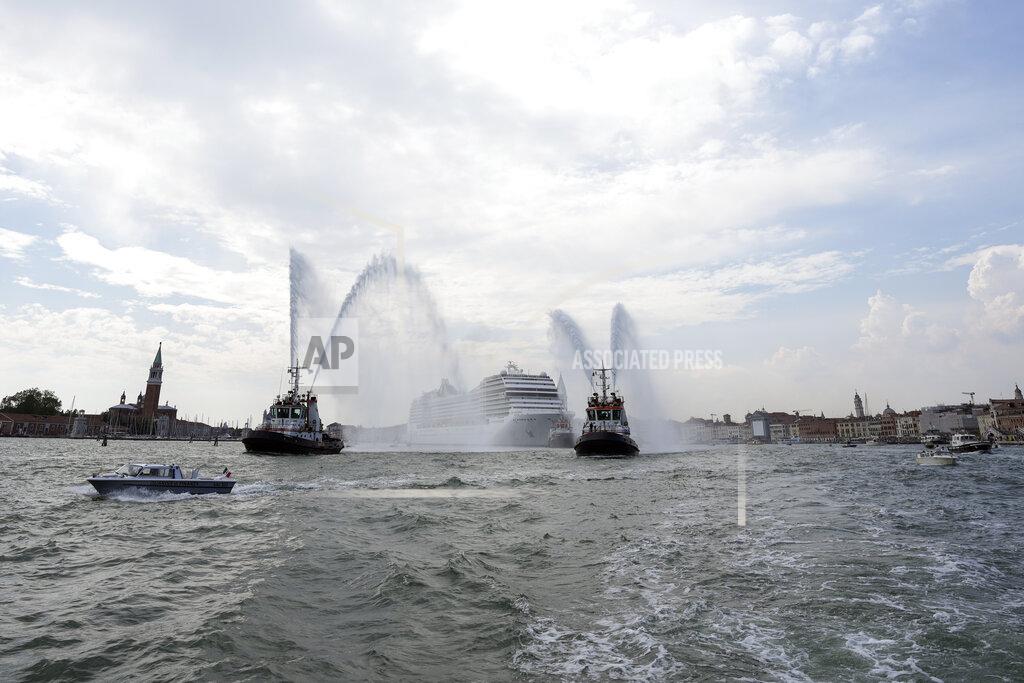 Antonio Calanni The MSC Orchestra cruise ship, center, leaves Venice, Italy, Saturday, June 5, 2021. The 92,409-ton, 16-deck MSC Orchestra cruise ship, the first cruise ship leaving Venice since the pandemic, is set to depart Saturday amid protests by activists demanding that the enormous ships be permanently rerouted out the fragile lagoon, especially Giudecca Canal through the city's historic center, due to environmental and safety risks. The ship passed two groups of protesters: pro-cruise advocates whose jobs depend on the industry as well as protesters who have been campaigning for years to get cruise ships out of the lagoon. (AP Photo/Antonio Calanni)