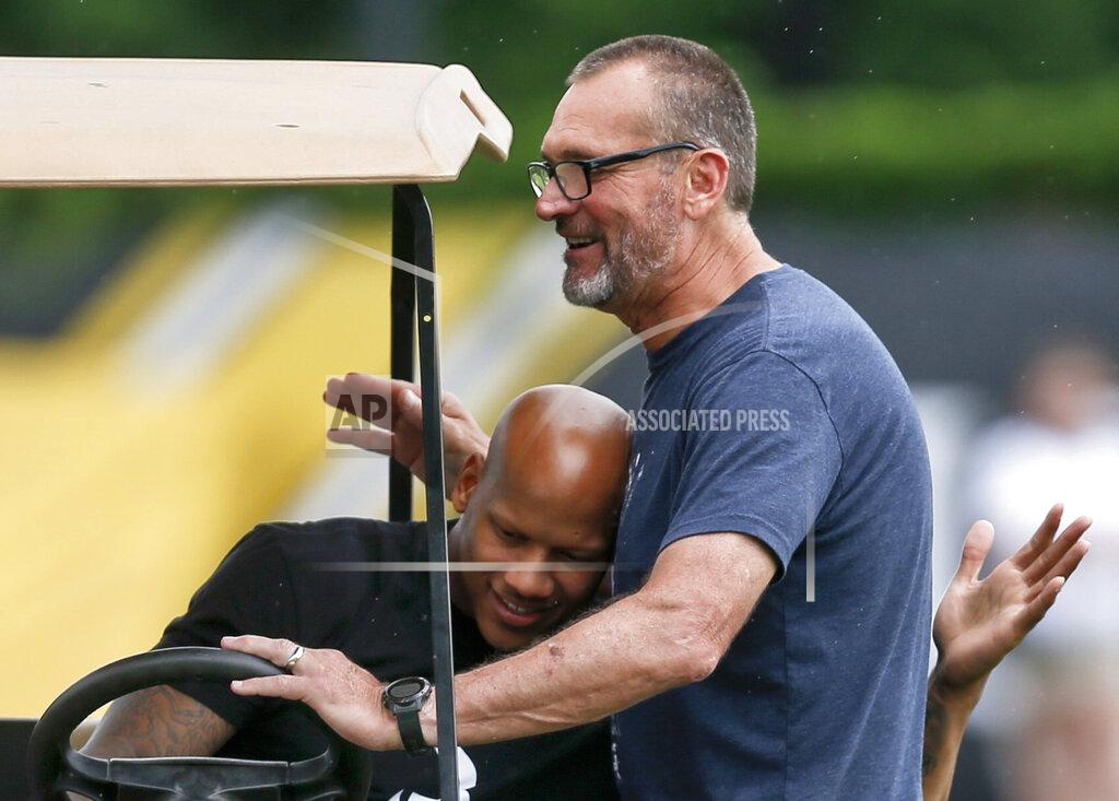 Keith Srakocic FILE - In this May 31, 2018, file photo, injured Pittsburgh Steelers linebacker Ryan Shazier, left, and former Steelers lineman and current broadcaster, Tunch Ilkin, embrace at an NFL football practice in Pittsburgh. Ilkin, a Turkis-born two-time Pro Bowl offensive lineman with the Pittsburgh Steelers in the 1980s who went on to become a beloved member of the organization's broadcast team, died on Saturday morning, Sept. 4, 2021, the team said. He was 63. Ilkin, who revealed last fall he was fighting amyotrophic lateral sclerosis (also known as Lou Gehrig's Disease), had been hospitalized recently with pneumonia. (AP Photo/Keith Srakocic, File)