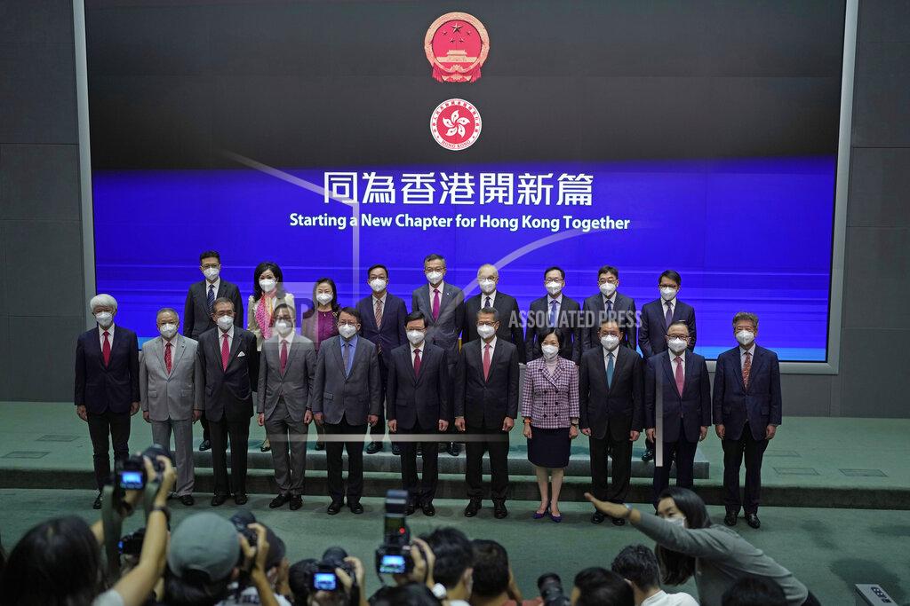 Kin Cheung Hong Kong Chief Executive John Lee, front center, lines up with his new members of cabinet during a news conference in Hong Kong, Tuesday, July 5, 2022. Lee said Tuesday in his first news conference since taking the reins that he will work towards legislating easing restrictions for travelers, but that it must be balanced with limiting the spread of the coronavirus so as not to overwhelm the healthcare system. (AP Photo/Kin Cheung)