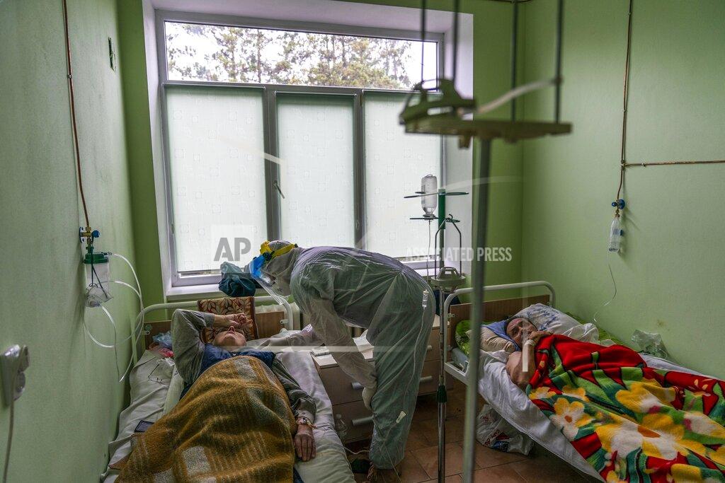 Evgeniy Maloletka Dr. Oleh Hornostayev speaks to a coronavirus patient at a hospital intensive care unit in Stryi, Ukraine, on Tuesday, Sept. 29, 2020. Coronavirus infections in Ukraine began surging in late summer, and the ripples are hitting towns in the western part of the country. The government wants to avoid imposing a new lockdown, but officials acknowledge that the rising infections could make it necessary. (AP Photo/Evgeniy Maloletka)
