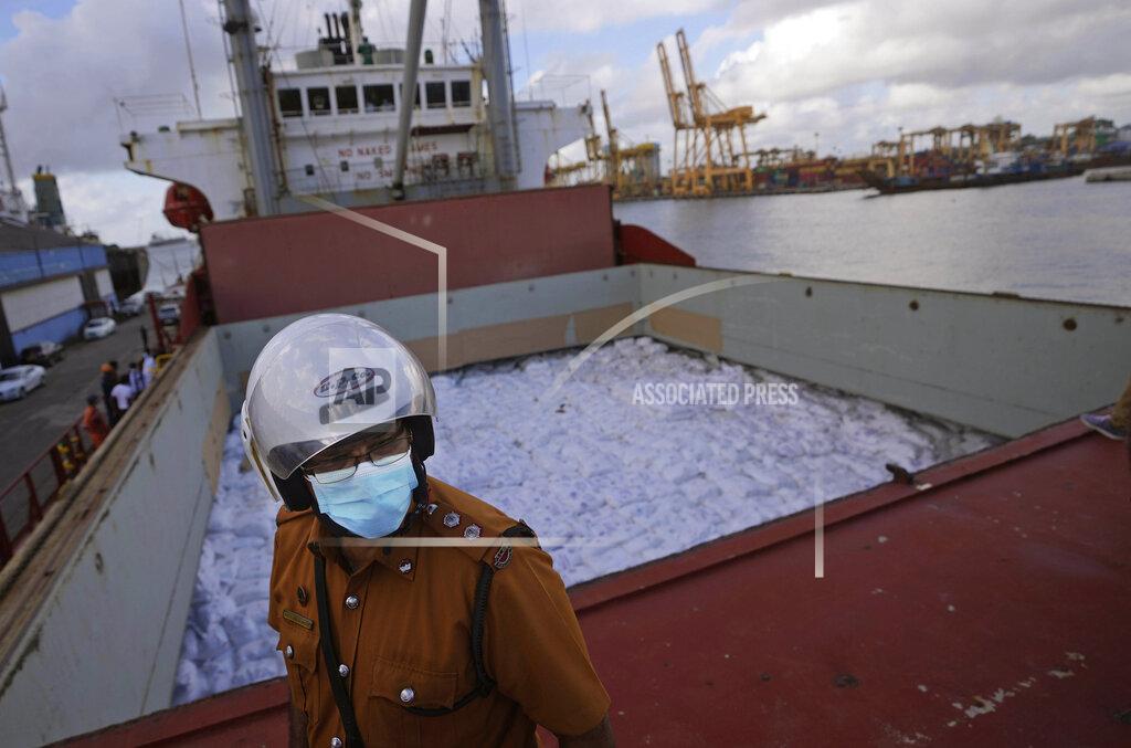 Eranga Jayawardena A Sri Lankan port worker stands on a ship that carried emergency supplies granted as humanitarian aid by India government to Sri Lankan people at a port in Colombo, Sri Lanka, Sunday, May 22, 2022. (AP Photo/Eranga Jayawardena)