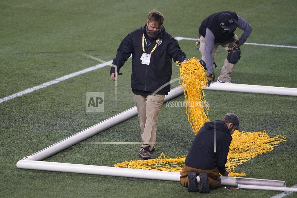 Ted S. Warren Workers take down a goal and net at CenturyLink Field following an MLS soccer match between the Seattle Sounders and Los Angeles FC, Friday, Sept. 18, 2020, in Seattle. The stadium is being prepared for Sunday's NFL football game between the Seattle Seahawks and the New England Patriots. (AP Photo/Ted S. Warren)