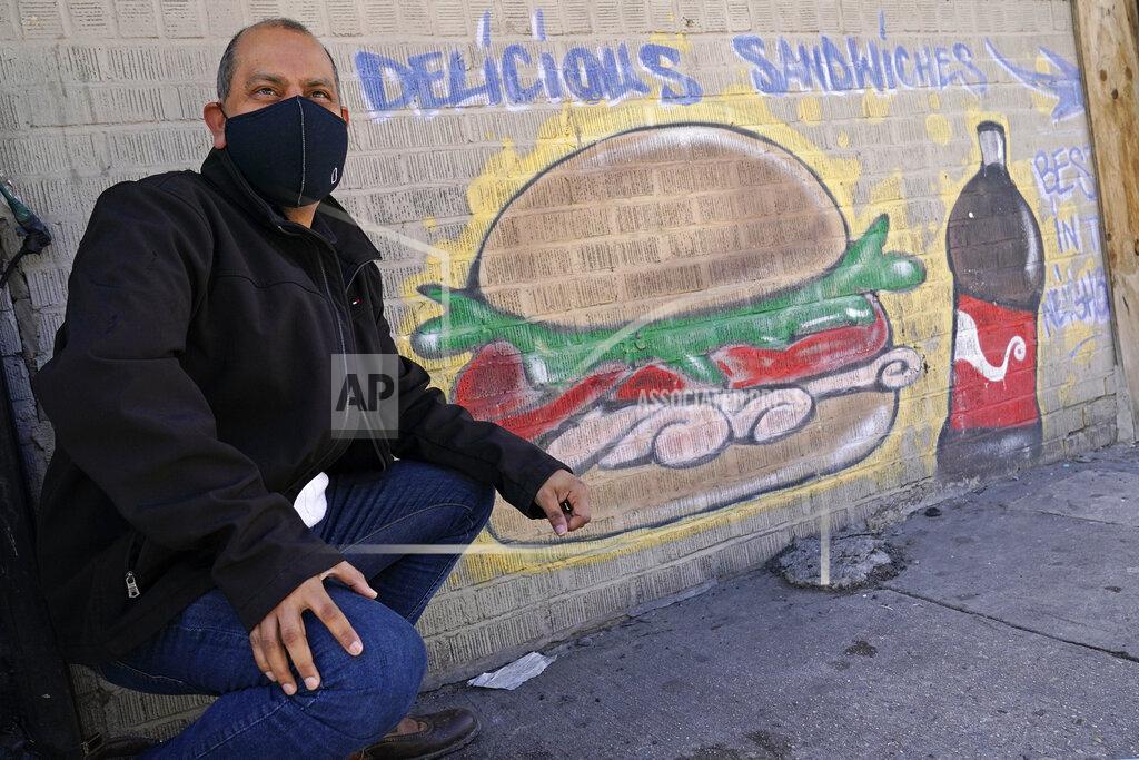 Kathy Willens Bodega owner Francisco Marte poses in front of a sign outside his deli-style store, Wednesday, Feb. 10, 2021, in the Bronx borough of New York. Marte president of the Bodega and Small Business Association of New York, which represents bodegas in New York, says he's lobbied local officials to set aside COVID-19 vaccine appointments for bodega workers, many of whom are unaware they are eligible.(AP Photo/Kathy Willens)