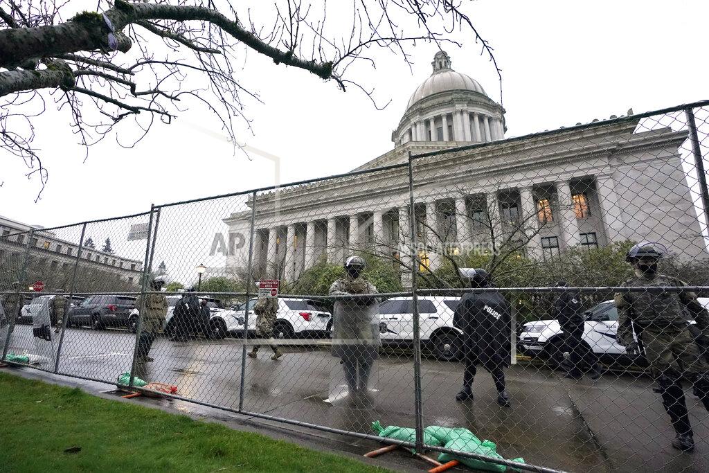 Ted S. Warren FILE - In this Jan. 11, 2021 file photo, members of the Washington National Guard stand near a fence surrounding the Capitol in anticipation of protests on the first day of the 2021 legislative session in Olympia, Wash. The 2021 session of the Washington Legislature ended Sunday, April 25 and lawmakers had no shortage of weighty topics to consider while having to conduct their work amid a pandemic that meant most meetings and votes were conducted remotely. The Capitol building was also closed to the public since last year due to the COVID-19 pandemic, and was surrounded by security fencing and national guard members at times due to fears of protests. (AP Photo/Ted S. Warren, File)
