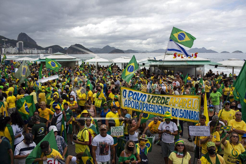 Bruna Prado People gather on Copacabana Beach in a demonstration backing President Jair Bolsonaro’s anti-coronavirus-lockdown stance, marking May Day, or International Workers' Day, in Rio de Janeiro, Brazil, Saturday, May 1, 2021. Brazil has seen over 400,000 confirmed COVID-19 deaths, a toll second only to the United States. (AP Photo/Bruna Prado)