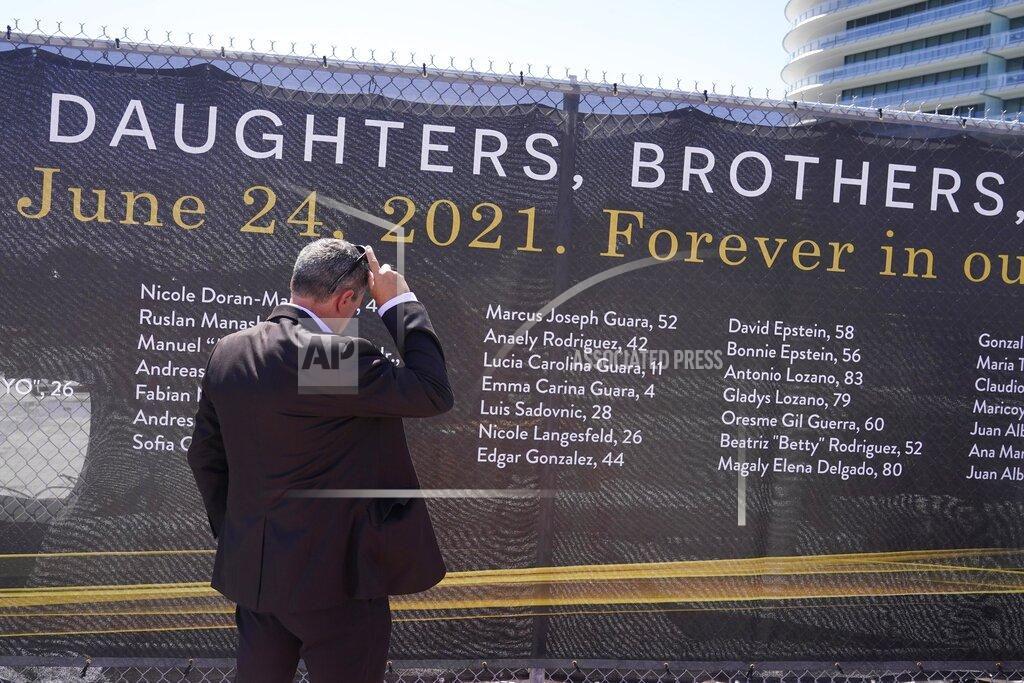 Marta Lavandier FILE - Pablo Langesfeld looks at the name of his daughter Nicole Langesfeld, Thursday, May 12, 2022, in Surfside, Fla., on a large banner with the names of the 98 killed in the collapse of the Champlain Towers South building. Attorneys for the families who lost relatives or homes in last year’s collapse of a Florida condominium tower that killed 98 people finalized a $1 billion settlement on Friday, May 27, 2022. (AP Photo/Marta Lavandier, File)