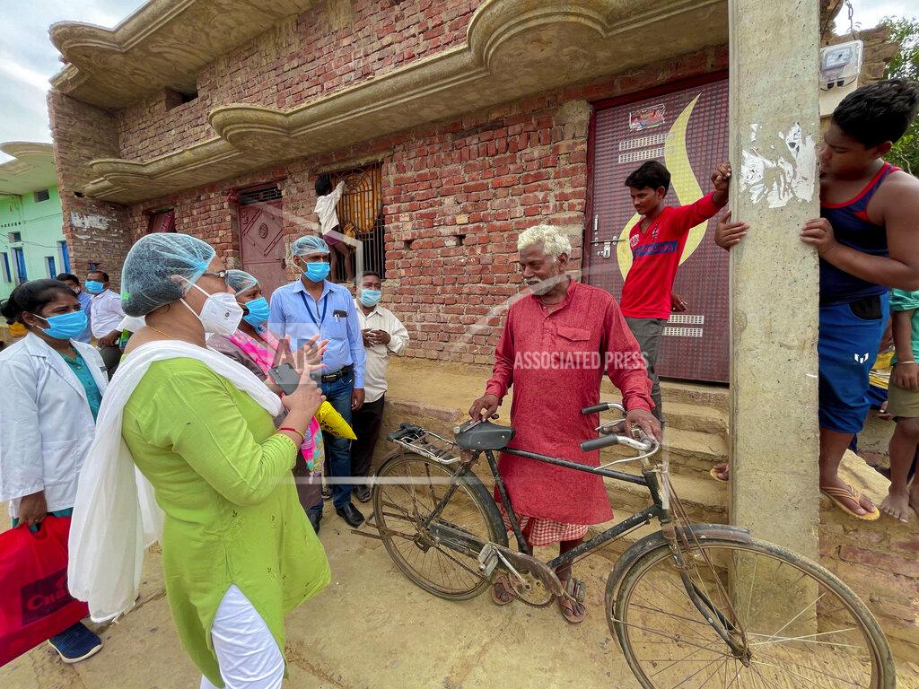 Rajesh Kumar Singh Health workers persuade Indian villager Pana Lall, 60, center, to get vaccinated against the coronavirus at Sikanderpur village, Uttar Pradesh state, India, on June 9, 2021. India's vaccination efforts are being undermined by widespread hesitancy and fear of the jabs, fueled by misinformation and mistrust. That's especially true in rural India, where two-thirds of the country’s nearly 1.4 billion people live. (AP Photo/Rajesh Kumar Singh)
