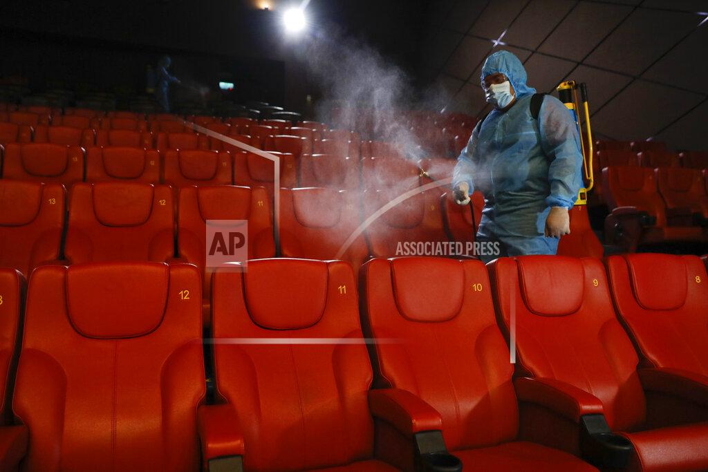 Vincent Thian A staff member of a cinema sprays disinfectant at the cinema hall to prepare for reopening on July 1 in Kuala Lumpur, Malaysia, Friday, June 26, 2020. Malaysia entered the Recovery Movement Control Order (RMCO) after three months of coronavirus restrictions. (AP Photo/Vincent Thian)