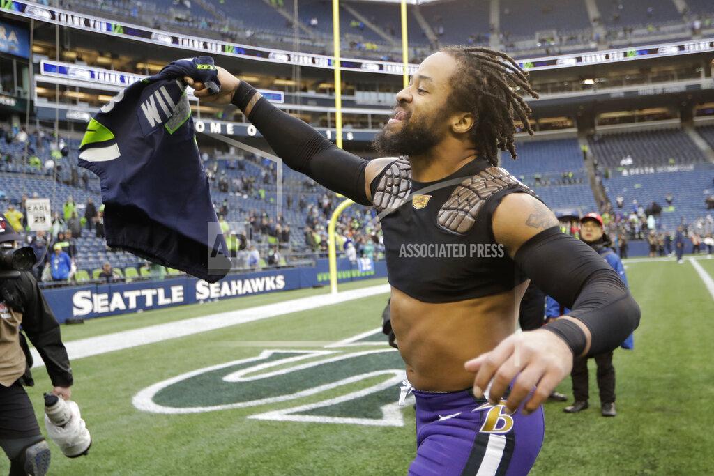 John Froschauer Baltimore Ravens free safety Earl Thomas waves the game jersey of Seattle Seahawks quarterback Russell Wilson after he and Wilson, who used to be teammates, traded jerseys after an NFL football game, Sunday, Oct. 20, 2019, in Seattle. (AP Photo/John Froschauer)