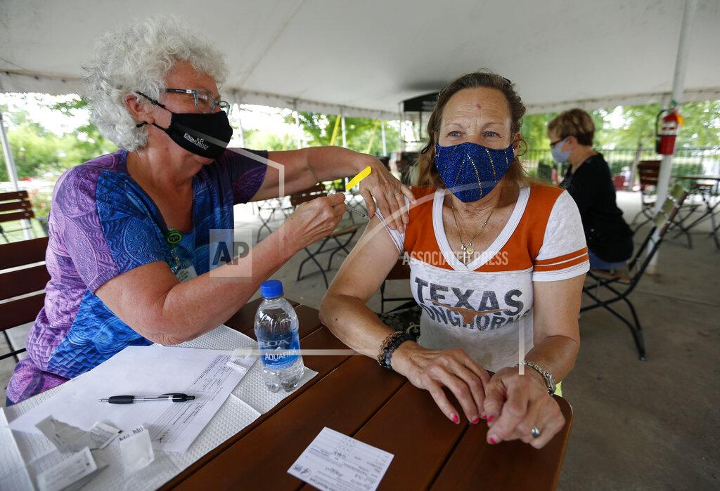 Nathan Papes Retired RN Barbara Vicente administers a shot of the Pfizer vaccine to Bobbie Guillette, 68, from Austin, Texas, at a clinic at Mother's Brewing Company in Springfield, Mo., on Tuesday, June 22, 2021. Guillette was visiting family in Springfield a took up Mother's Brewing on their offer a free beer for getting a vaccine shot. (Nathan Papes/The Springfield News-Leader via AP)