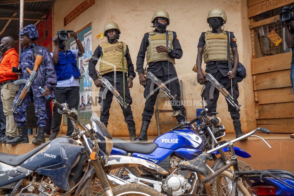 Jerome Delay Security forces stand outside a polling station in Kampala, Uganda, Thursday, Jan. 14, 2021. Ugandans are voting in a presidential election tainted by widespread violence that some fear could escalate as security forces try to stop supporters of leading opposition challenger Bobi Wine from monitoring polling stations. (AP Photo/Jerome Delay)