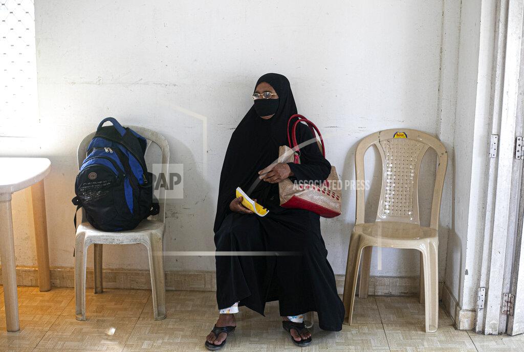 A woman waits to test for COVID-19 during a random test for the family members of army personnel at the army base hospital in Gauhati, India, Monday, Oct. 19, 2020. (AP Photo/Anupam Nath)
