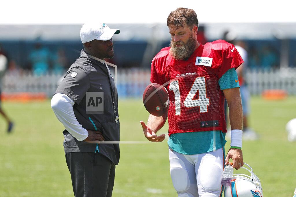 Miami Dolphins quarterback Ryan Fitzpatrick (14) talks with head coach Brian Flores after the teams NFL football training camp, Tuesday, July 30, 2019, in Davie, Fla. Flores says Fitzpatrick has become the front-runner in the Miami Dolphins' quarterback competition ahead of Josh Rosen. (AP Photo/Wilfredo Lee)