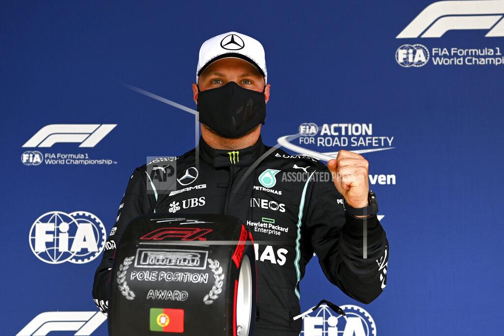 Gabriel Buoys Mercedes driver Valtteri Bottas of Finland poses after he clocked the fastest time during the qualifying session ahead of the Portugal Formula One Grand Prix at the Algarve International Circuit near Portimao, Portugal, Saturday, May 1, 2021. The Portugal Grand Prix will be held on Sunday. (Gabriel Buoys/Pool via AP)