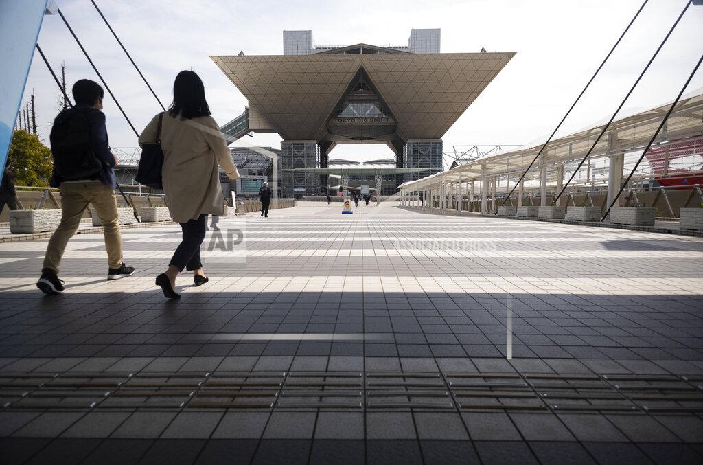 Hiro Komae People walk towards the Tokyo International Exhibition Center, also known as Tokyo Big Sight, in Tokyo Thursday, April 8, 2021. The exhibition center is a planned venue for the Tokyo 2020 Olympic and Paralympic Games, rescheduled to start in July 2021. Many preparations are still up in the air as organizers try to figure out how to hold the postponed games in the middle of a pandemic. (AP Photo/Hiro Komae)