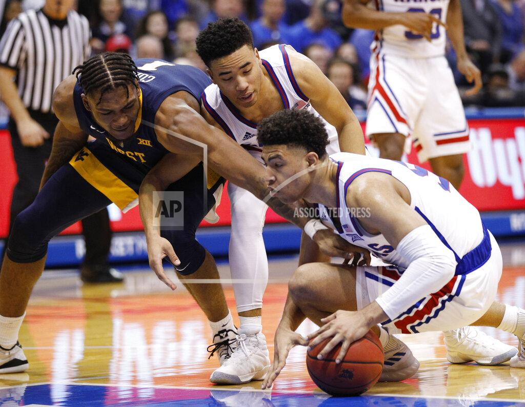 Colin E. Braley West Virginia guard Jordan McCabe (5) and Kansas guards Devon Dotson and Quentin Grimes (5) go after a loose ball during the second half of an NCAA college basketball game Saturday, Feb. 16, 2019, in Lawrence, Kan. (AP Photo/Colin E. Braley)