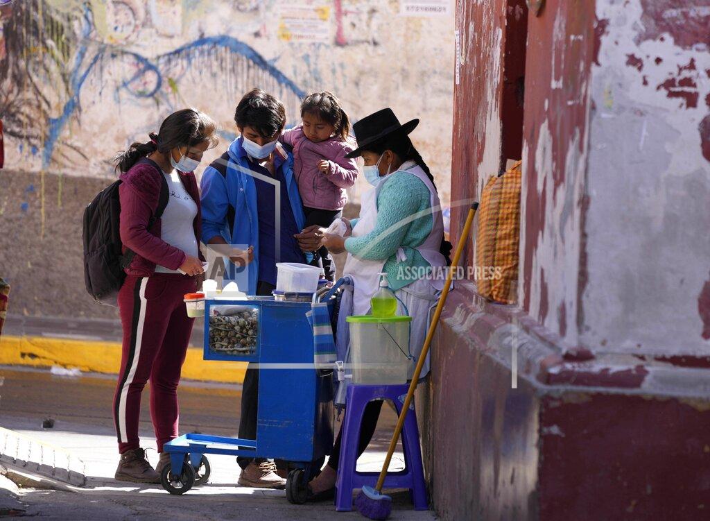 Martin Mejia A family buys quail eggs from an Indigenous vendor in Huamanga, Peru, Thursday, Sept. 2, 2021. Halting efforts to promote the Quechua language hit the spotlight last month when Peru’s new prime minister surprised the nation by delivering a speech in the Indigenous tongue to Congress for the first time in Peru’s history. (AP Photo/Martin Mejia)