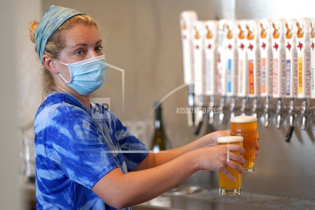 David J. Phillip Bartender Katie McGranahan pours beers at the Saint Arnold Brewing Company Friday, June 26, 2020, in Houston. Texas Gov. Greg Abbott announced Friday that he is shutting bars back down and scaling back restaurant capacity to 50%, in response to the increasing number of COVID-19 cases in Texas. (AP Photo/David J. Phillip)