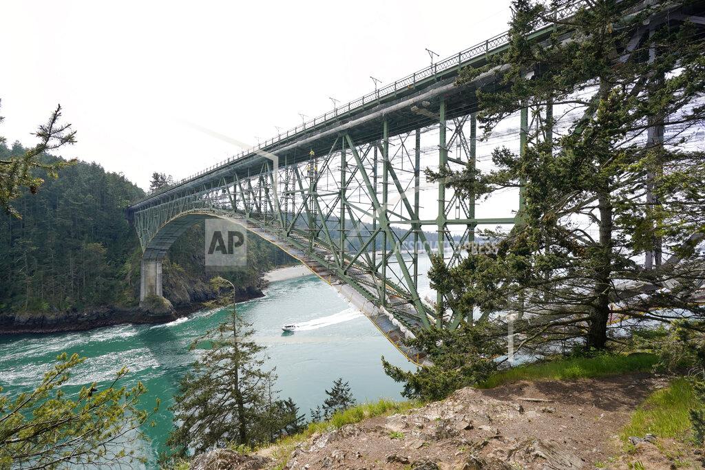 Elaine Thompson The Deception Pass Bridge, nearly 1,000-feet long and about 180-feet above the waters below, is covered in scaffolding as work to replace corroded steel and paint the structure continues Thursday, April 29, 2021, in Deception Pass, Wash. Raising state taxes to improve roads and bridges is one of the few things many Republican and Democratic lawmakers have agreed on in recent years. Those efforts have slowed to a crawl this year, even as lawmakers acknowledge a widening gap between needed work and the money to pay for it. (AP Photo/Elaine Thompson)