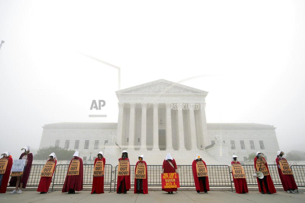 Jose Luis Magana Activists opposed to the confirmation of President Donald Trump's Supreme Court nominee, Judge Amy Coney Barrett, dressed as characters from "The Handmaid's Tale," protest at the Supreme Court on a foggy day, Thursday, Oct. 22, 2020, on Capitol Hill in Washington. (AP Photo/Jose Luis Magana)